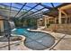 Extravagant screened-in pool area complete with water features, and outdoor kitchen and lush landscaping at 695 Se 47Th Loop, Ocala, FL 34480