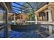 Beautiful black tiled pool with multiple water features in a screened-in enclosure at 695 Se 47Th Loop, Ocala, FL 34480