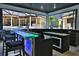 Entertain at the poolside bar featuring a bar fridge, granite countertops, and seating with views of the pool and yard at 695 Se 47Th Loop, Ocala, FL 34480