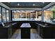 A fully-equipped outdoor bar boasts stone countertops, storage, and views of the luxurious swimming pool at 695 Se 47Th Loop, Ocala, FL 34480