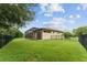 Large backyard featuring a black fence and screened-in patio, offering plenty of space for recreation and privacy at 7839 Sw 97Th Cir, Ocala, FL 34481