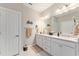 Bright bathroom featuring double sinks, granite countertops, white cabinetry, and modern fixtures at 7839 Sw 97Th Cir, Ocala, FL 34481