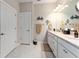 Bright bathroom featuring double sinks, granite countertops, white cabinetry, and modern fixtures at 7839 Sw 97Th Cir, Ocala, FL 34481