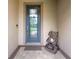Stylish front door with decorative glass panel and a charming porch arrangement at 7839 Sw 97Th Cir, Ocala, FL 34481