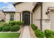 Close up of front entrance with a secure door, stone accents, and lush landscaping at 7839 Sw 97Th Cir, Ocala, FL 34481