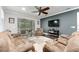 Comfortable living room with reclining sofas, ceiling fan, and access to the outdoor patio at 7839 Sw 97Th Cir, Ocala, FL 34481