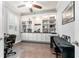 Bright home office featuring custom built-ins, a ceiling fan, and a large window at 7839 Sw 97Th Cir, Ocala, FL 34481
