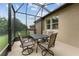 Charming screened patio featuring a dark dining table and chairs, perfect for outdoor meals and gatherings at 7839 Sw 97Th Cir, Ocala, FL 34481