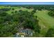 Aerial view showcasing mature trees surrounding the home as well as views of the golf course at 7961 Midway Drive Ter # J102, Ocala, FL 34472