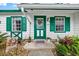 Inviting front door with green trim, a hanging flower basket, and decorative windows add charm to the entrance at 7961 Midway Drive Ter # J102, Ocala, FL 34472