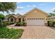 Inviting home with a brick walkway, stone accents, manicured landscaping, and a two-car garage at 8611 Sw 83Rd Loop, Ocala, FL 34481