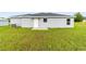 View of the home's exterior, showing a well-manicured lawn and rear entrance, with a spacious backyard at 87 Redwood Rd, Ocala, FL 34472