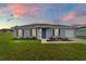 Single-story house with an idyllic sunset, green lawn, and blue shutters, providing a peaceful ambiance at 87 Redwood Rd, Ocala, FL 34472