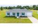 Charming single-story home with a well-kept lawn, blue shutters and a freshly poured concrete driveway at 87 Redwood Rd, Ocala, FL 34472
