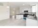 Modern kitchen offering white cabinets, stainless steel appliances, dark countertops, and adjacent living area at 87 Redwood Rd, Ocala, FL 34472