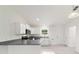 Modern kitchen with white cabinets, dark countertops, and stainless steel appliances, illuminated by natural light at 87 Redwood Rd, Ocala, FL 34472