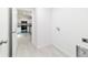 Pass through laundry room looking into a kitchen featuring white cabinets and stainless appliances at 87 Redwood Rd, Ocala, FL 34472