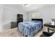 Cozy bedroom with dark furniture, plush blue bedding, and tile flooring, creating a serene and inviting atmosphere at 8940 Se 87Th Ter, Ocala, FL 34472