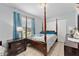 Comfortable bedroom with a four-poster bed, complemented by bright blue accents and tile flooring at 8940 Se 87Th Ter, Ocala, FL 34472