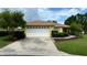Charming single-story home with a well-manicured lawn, a two-car garage, and yellow paint at 9490 Sw 94Th Ct, Ocala, FL 34481