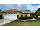 Charming single-story home with a well-manicured lawn, a two-car garage, and yellow paint at 9490 Sw 94Th Ct, Ocala, FL 34481