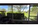 View from lanai overlooks lush green lawn with manicured hedges and mature shade trees in the distance at 9490 Sw 94Th Ct, Ocala, FL 34481