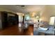 Open living room with hardwood floors, modern sofas, and views of front yard and the door to enter the property at 9490 Sw 94Th Ct, Ocala, FL 34481