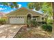 Charming home featuring a well-manicured lawn, attached garage, and inviting entryway at 9587 Sw 84Th Ter # E, Ocala, FL 34481
