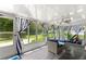 Bright sunroom featuring blue and white striped curtains, stylish furniture and outdoor views at 9587 Sw 84Th Ter # E, Ocala, FL 34481