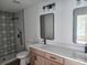 Modern bathroom featuring patterned shower tile, stylish mirrors, and dual sinks at 9721 Bahia Rd, Ocala, FL 34472