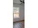 Bedroom featuring wood-look floors, a modern ceiling fan, and a window with a view at 9721 Bahia Rd, Ocala, FL 34472