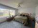 Spacious bedroom with neutral carpeting, a ceiling fan, and a large window overlooking the yard at 9730 Sw 90Th St, Ocala, FL 34481