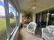 Enclosed lanai with white wicker furniture, ceiling fan, and sliding glass doors at 9730 Sw 90Th St, Ocala, FL 34481