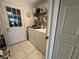 Laundry area with a white door to the backyard, plus washer, dryer, and shelving at 9730 Sw 90Th St, Ocala, FL 34481