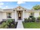 Inviting entryway with a dark wood door, manicured landscaping and decorative stone accents at 9957 Sw 45Th Ave, Ocala, FL 34476