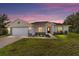 Charming single-story home with a well-manicured lawn and inviting curb appeal at dusk at 9957 Sw 45Th Ave, Ocala, FL 34476