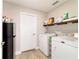 Tidy laundry room is equipped with washer, dryer, and extra shelving at 9957 Sw 45Th Ave, Ocala, FL 34476