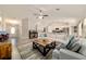 Spacious living room showcasing a comfortable sofa, stylish rug, and an open layout leading to the kitchen at 9957 Sw 45Th Ave, Ocala, FL 34476