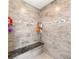 Shower features beautiful stone tiling, a built-in bench, and decorative accent tiles at 9957 Sw 45Th Ave, Ocala, FL 34476