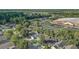 Wide aerial shot of neighborhood homes near schools, roads, and parking lots, all surrounded by mature trees at 125 Placid Woods Ct, Sanford, FL 32773