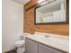 Modern bathroom with wood-look accent wall, neutral gray vanity, and a clean, minimalist design at 125 Placid Woods Ct, Sanford, FL 32773
