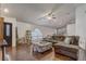 Open-concept living room features hardwood floors, a ceiling fan, and a comfortable sofa at 125 Placid Woods Ct, Sanford, FL 32773