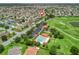 Aerial view highlighting the community pool, parking, and golf course in a residential area at 1266 James Island St, The Villages, FL 32162