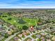 Scenic aerial view of a community featuring a golf course and water features at 1266 James Island St, The Villages, FL 32162