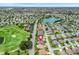 Aerial view of a golf community, showcasing the home's location near a golf course and lake at 1266 James Island St, The Villages, FL 32162