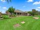 Expansive backyard showcasing lush greenery, a patio area, and meticulously maintained landscaping at 1266 James Island St, The Villages, FL 32162