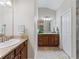 Dual vanities with granite countertops in a spacious bathroom with neutral tile flooring at 1266 James Island St, The Villages, FL 32162
