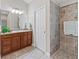 Bathroom features tile floors, a granite vanity, and a tiled walk-in shower with seat at 1266 James Island St, The Villages, FL 32162