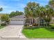 Charming home with well-manicured lawn and mature palm trees, showcasing the property's curb appeal at 1266 James Island St, The Villages, FL 32162