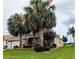 Charming home featuring lush landscaping, mature palm trees, and a well-manicured lawn at 1266 James Island St, The Villages, FL 32162